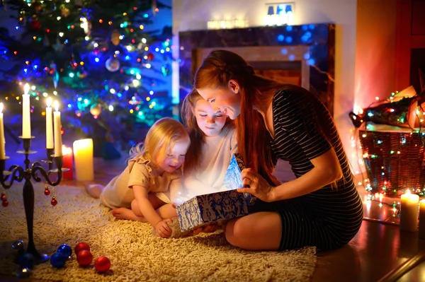Mother and  daughters opening  Christmas gift — Stock Photo, Image