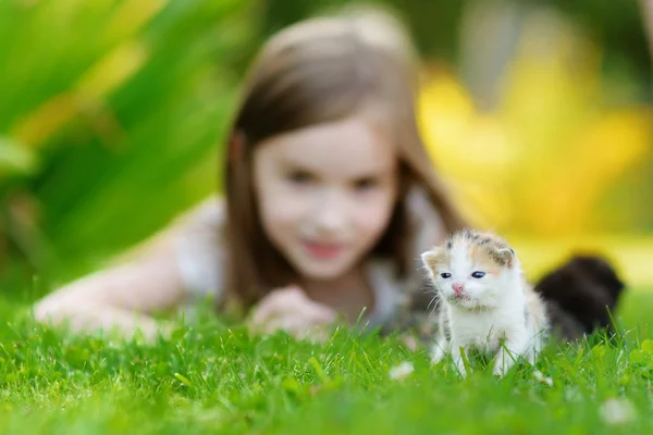 Flicka som leker med liten kattunge — Stockfoto