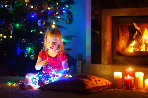 Petite fille jouant avec les lumières de Noël — Photo