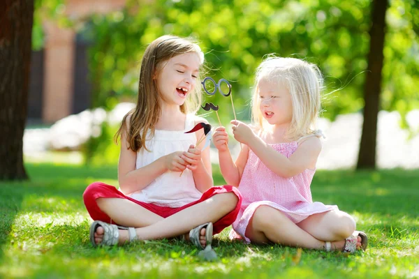 Girls playing with paper moustaches Royalty Free Stock Photos