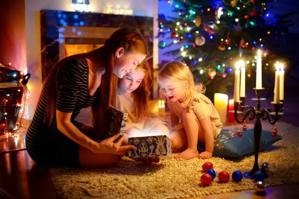 Mother and daughters opening Christmas gift — Stock Photo, Image