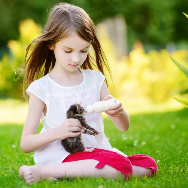 Menina alimentando pequeno gatinho — Fotografia de Stock