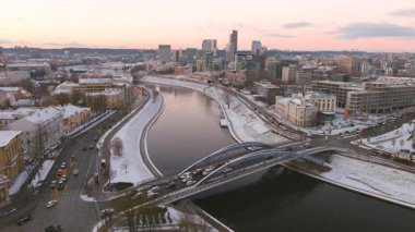Akşam karanlığında Neris Nehri ve Mindaugas Köprüsü 'nün manzaralı kış manzarası. Vilnius merkez ve şehir merkezindeki günbatımı manzarası. Litvanya Vilnius 'un akşam manzarası.