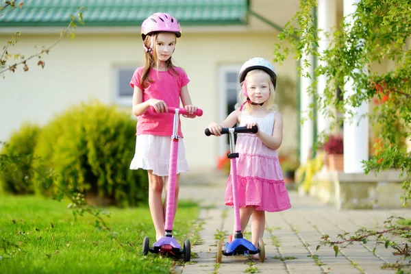 Hermanas pequeñas montando sus scooters —  Fotos de Stock