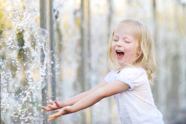 bir şehir çeşme ile oynayan kız