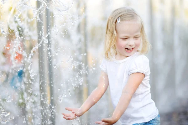 Fille jouer avec une fontaine de la ville — Photo