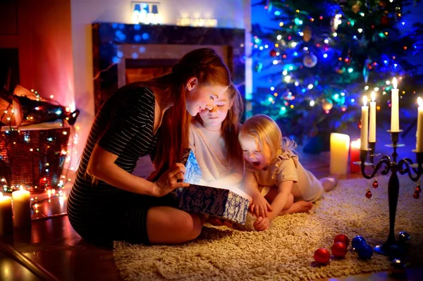 Mother and daughters opening Christmas gift — Stock Photo, Image