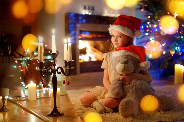 Ragazza seduta vicino a un camino la vigilia di Natale — Foto Stock