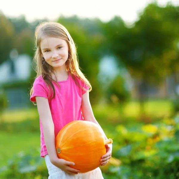 Little girl holding a pumpkin — Stock Photo, Image