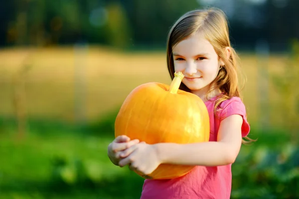 Little girl holding a pumpkin — Stock Photo, Image