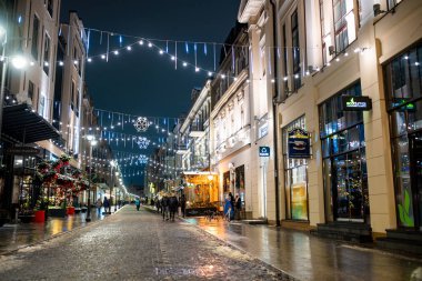 VILNIUS, LITHUANIA - 23 Aralık 2024: Vilnius Eski Kasabası 'nın dar sokakları Noel için süslenmiştir. Litvanya 'nın başkentinde Noel ve Yeni Yıl Kutlaması.