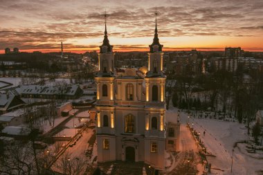 Kalvariju Kutsal Haç Keşfi Kilisesi kışın alacakaranlıkta sıcak bir şekilde parlar, yukarıdan görülür. Kutsal sakinlik, altın saat hava perspektifinde kentsel yayılımla buluşur..