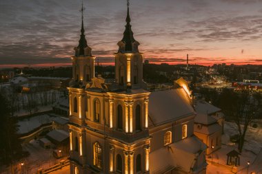 Kalvariju Kutsal Haç Keşfi Kilisesi kışın alacakaranlıkta sıcak bir şekilde parlar, yukarıdan görülür. Kutsal sakinlik, altın saat hava perspektifinde kentsel yayılımla buluşur..