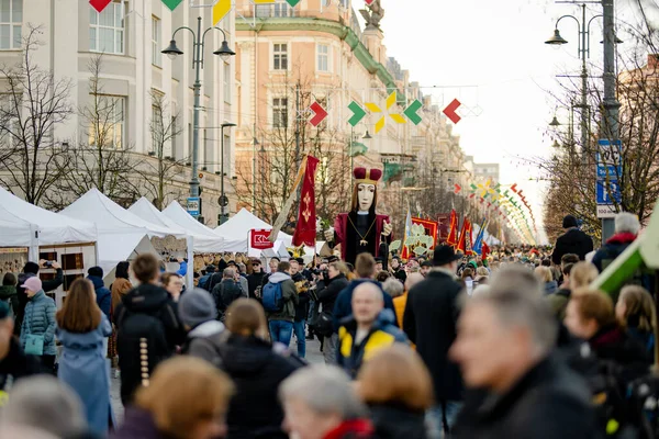 VILNIUS, LITHUANIA - 4 Mart 2025: Kaziuko muge veya Kaziukas, geleneksel Paskalya pazarı sırasında mizahi geçit törenine katılan neşeli insanlar, her Mart ayında Old Town sokaklarında el sanatları fuarı düzenleniyor.