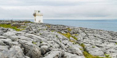 Burren 'in engebeli kayalık arazisinde yer alan Kara Başlı Deniz Feneri dik kireçtaşı dağları ve kayalık kıyı şeridi arasında yer alır..