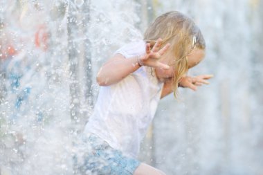 bir şehir çeşme ile oynayan kız