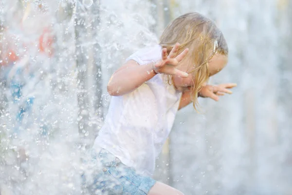 Fille jouer avec une fontaine de la ville — Photo