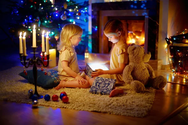 Маленькі дівчата відкривають різдвяний подарунок — стокове фото