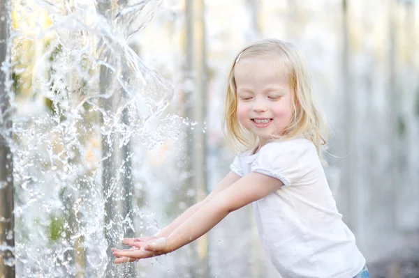 Girl playing with a city fountain — Stock Photo, Image