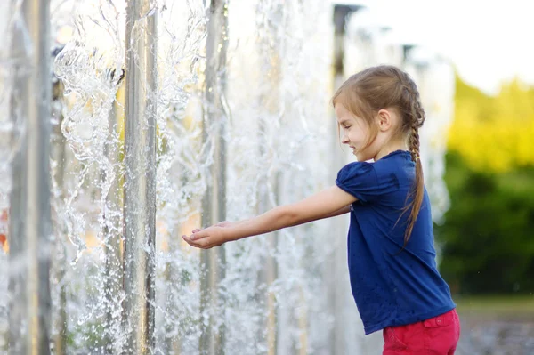 Dívka si hraje s fontánou město — Stock fotografie