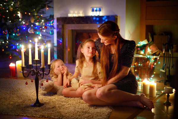 Mother and daughters near fireplace