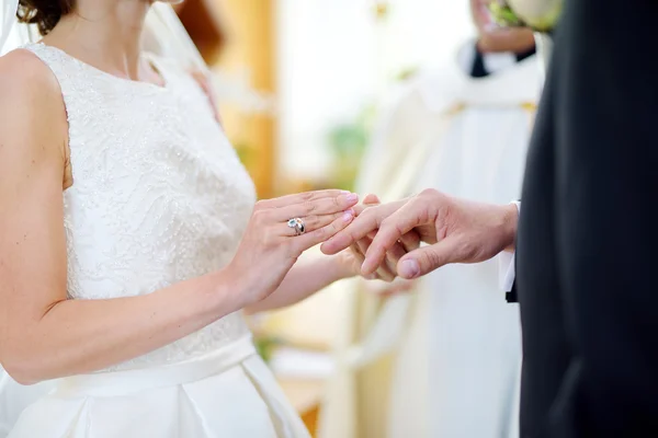 Novia poniendo un anillo en el dedo del novio — Foto de Stock