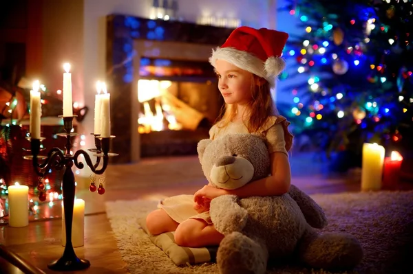 Fille assise près d'une cheminée la veille de Noël — Photo