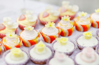 Beyaz bir tablo üzerinde bir şekilde dekore edilmiş cupcakes