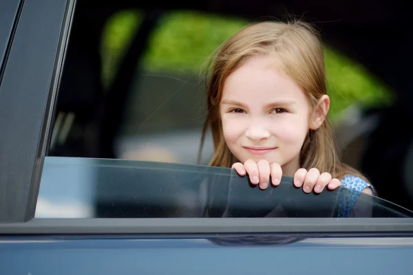 Meisje steekt haar hoofd uit de auto — Stockfoto