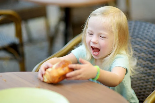 Kleines Mädchen isst Brötchen — Stockfoto