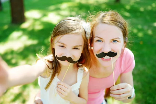 Madre e figlia con baffi di carta — Foto Stock
