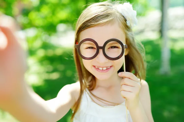 Menina brincando com óculos de papel — Fotografia de Stock