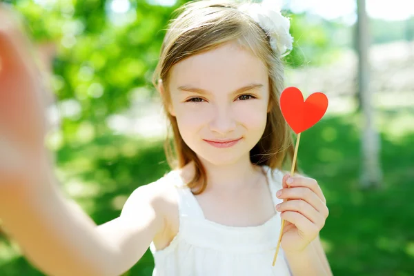 Menina brincando com papel coração — Fotografia de Stock