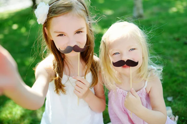 Meninas brincando com bigodes de papel — Fotografia de Stock