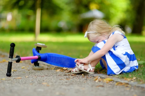 Flicka föll medan ridning hennes scooter — Stockfoto