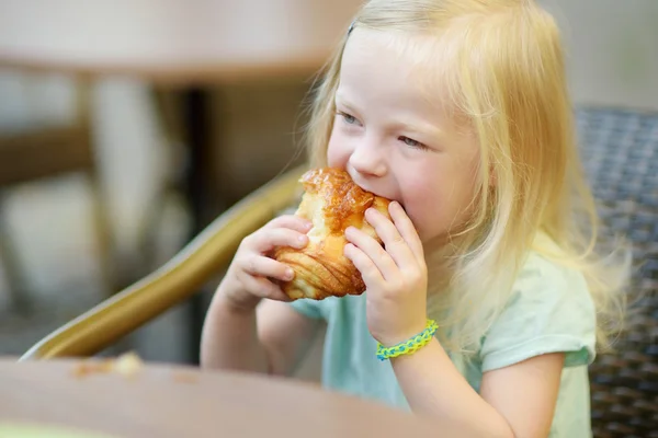 Entzückendes kleines Mädchen isst Brötchen — Stockfoto
