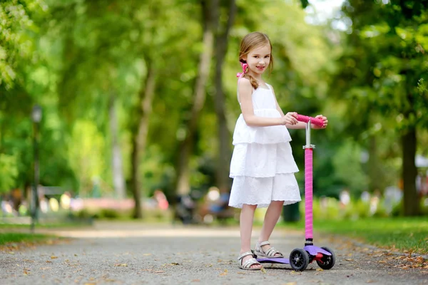 Küçük kız onun scooter sürme — Stok fotoğraf