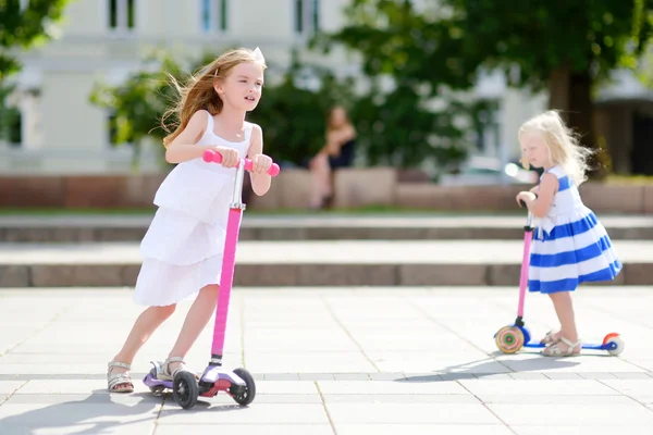 Hermanas montando sus scooters en un parque — Foto de Stock
