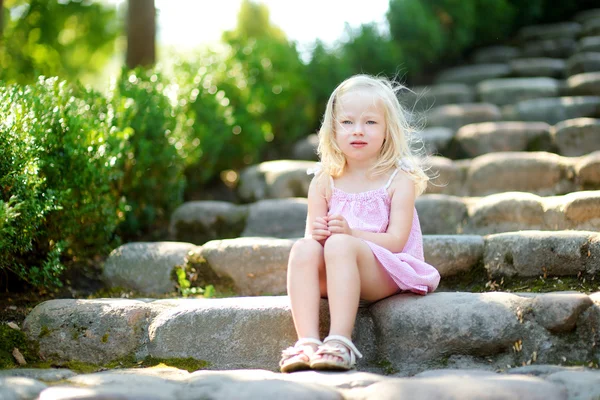 Очаровательная маленькая девочка сидит на лестнице — стоковое фото
