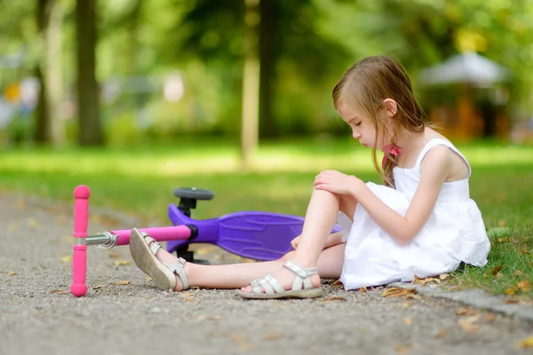 Meisje viel tijdens het rijden haar scooter — Stockfoto