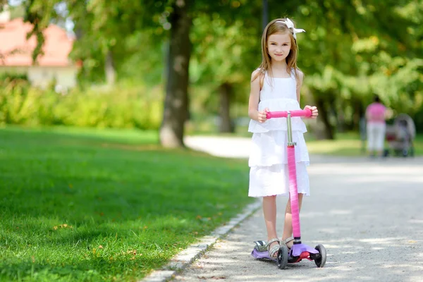 Chica montando su scooter en parque — Foto de Stock