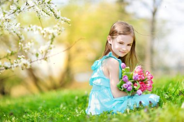 Sevimli küçük kız laleleri tutuyor