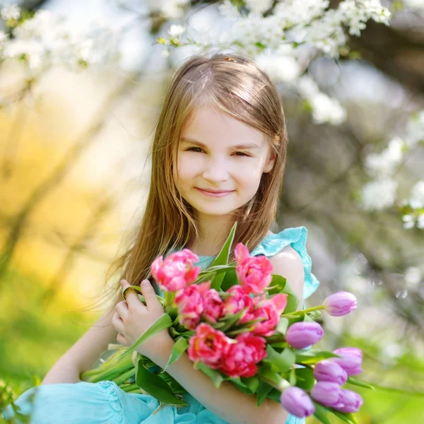 Entzückendes kleines Mädchen mit Tulpen — Stockfoto
