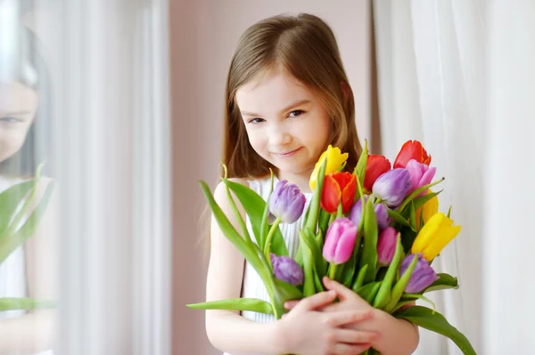 Маленькая девочка с красочными тюльпанами — стоковое фото
