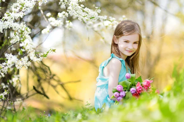 Rozkošná holčička drží tulipány — Stock fotografie