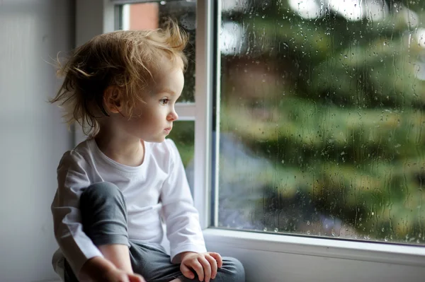 Menina embora olhando pela janela — Fotografia de Stock