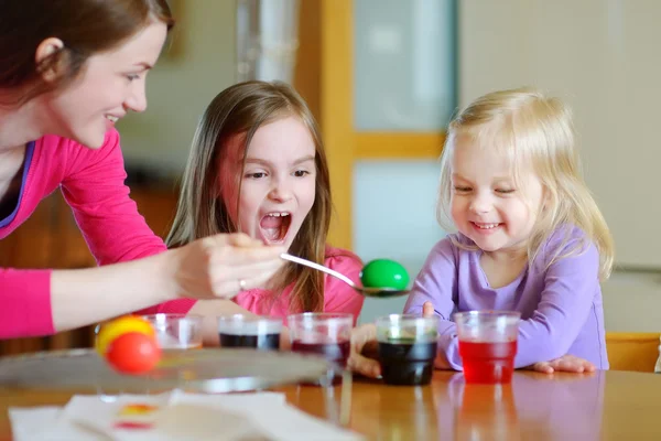 Madre e hijas pintando huevos de Pascua — Foto de Stock