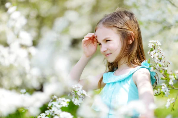 Liten flicka i blommande cherry garden — Stockfoto