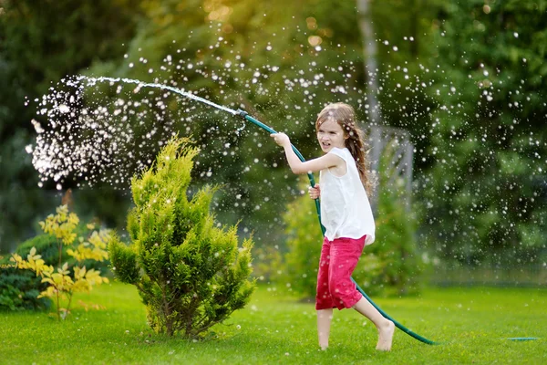 Chica jugando con una manguera de jardín —  Fotos de Stock