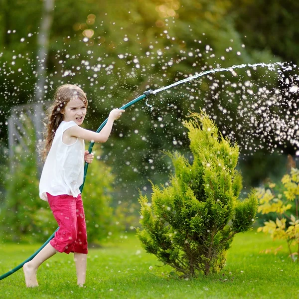 Meisje spelen met een tuinslang — Stockfoto